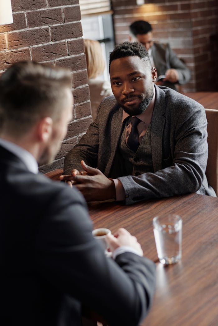 services-03 Two businessmen in suits chatting during a coffee break in a stylish café.